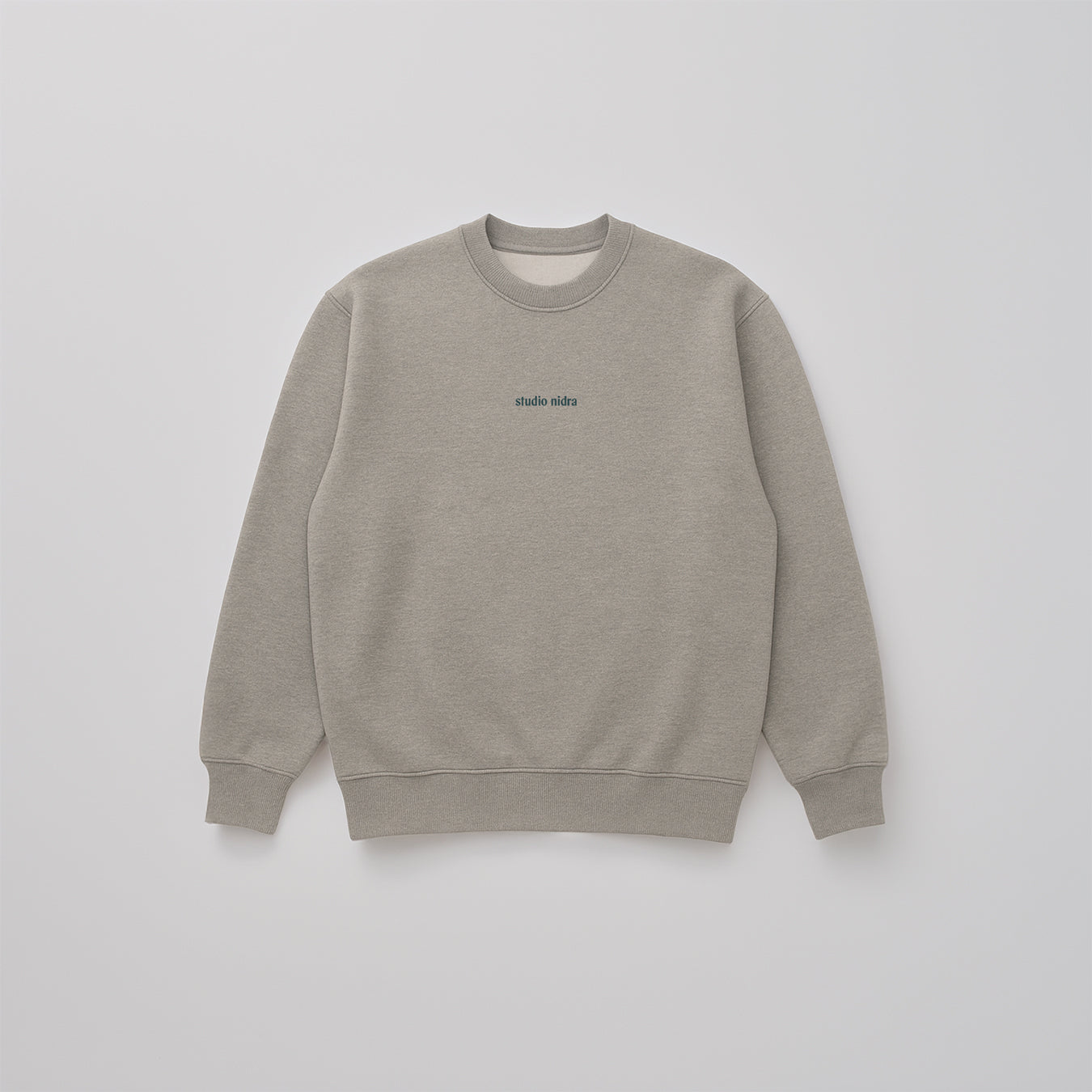 Flatlay image of Gray marle organic cotton sweatshirt in limited edition "Grey Matter" with a Studio Nidra logo embroidery on a light gray background