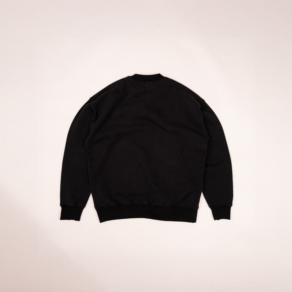 Back view of The Crew Sweatshirt in black by Studio Nidra, laying flat on light background.